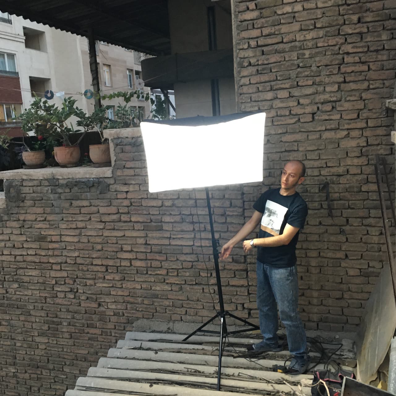 On set: a light panel set up beside a brick wall