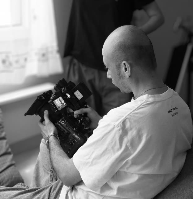 Black-and-white photo of Abolfazl Abasht framing a shot with a cinema camera